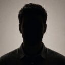 silhouette of a person with no visible facial features, wearing a collared shirt against a neutral background